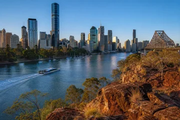 Brisbanes skyline och Story Bridge sedda från Kangaroo Point i skymningen